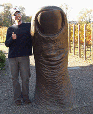 Professor Matthew Hahn standing next to a sculpture of a thumb. The sculpture is as tall as the professor.