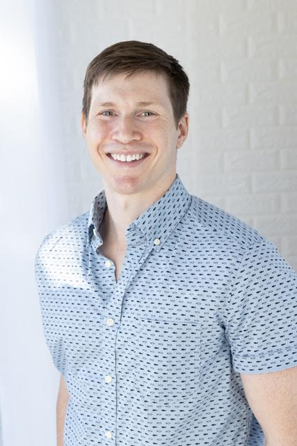 A picture of Isaac Miller-Crews smiling and wearing a short-sleeve button-down shirt.