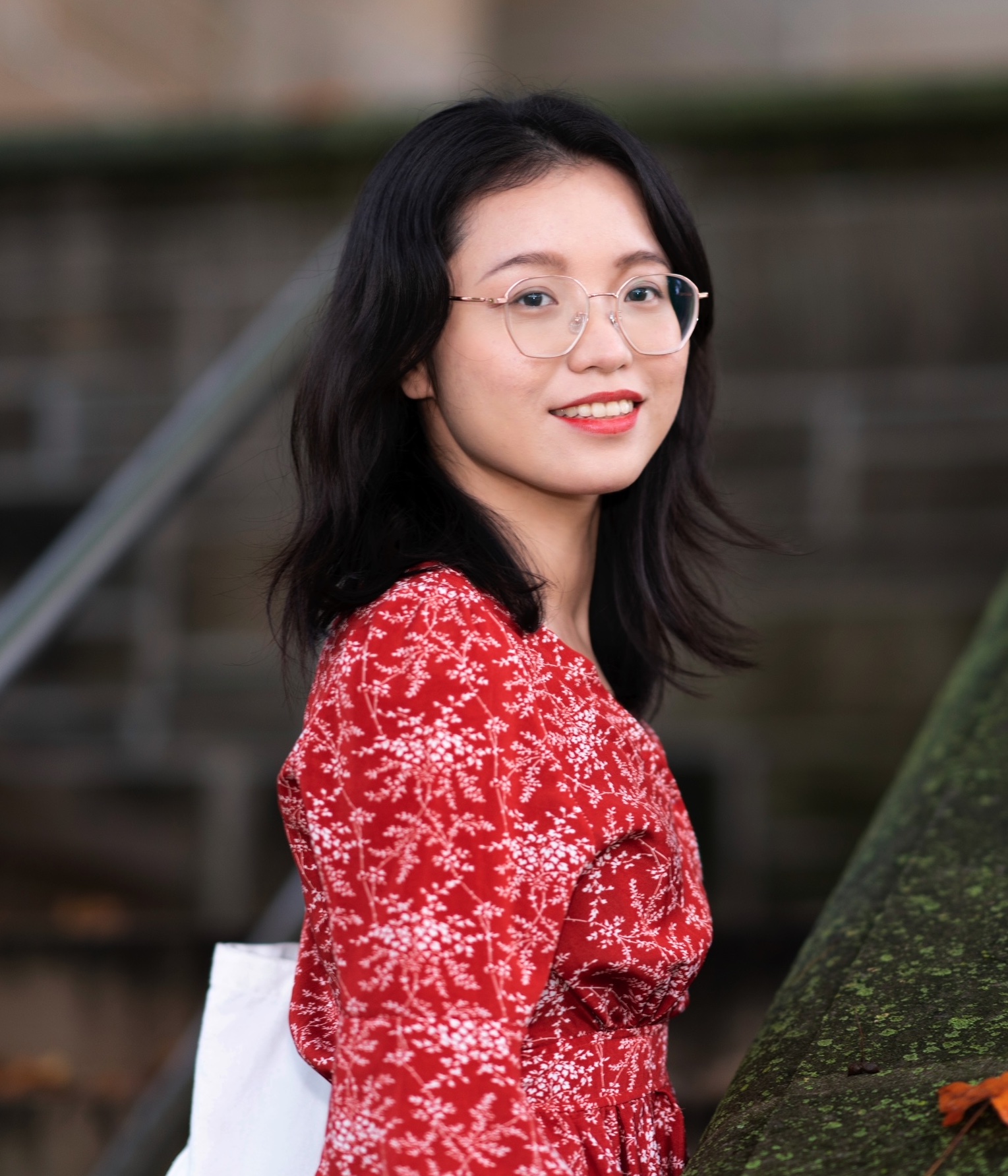 A picture of Yu Mo wearing a red blouse and glasses.